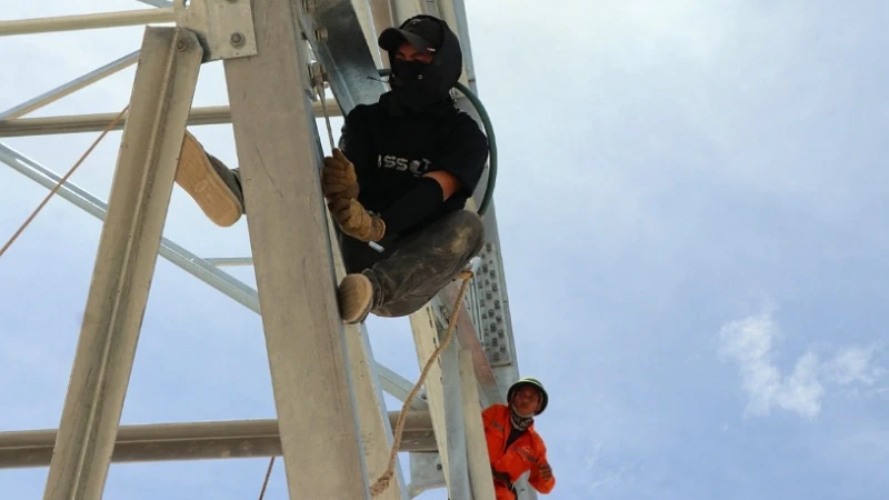 Công nhân cheo leo trên độ cao hàng chục mét để lắp dựng cột trong thời tiết nắng nóng gay gắt của mùa hè xứ Nghệ.