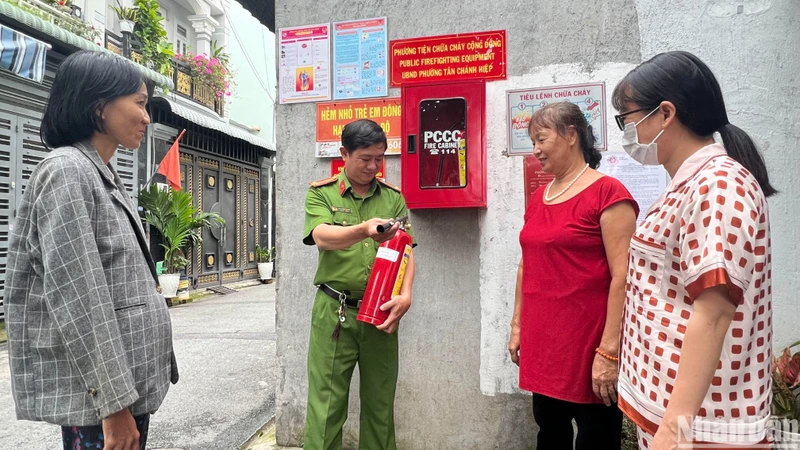 Công an phường Tân Chánh Hiệp (quận 12) hướng dẫn người dân sử dụng bình chữa cháy.