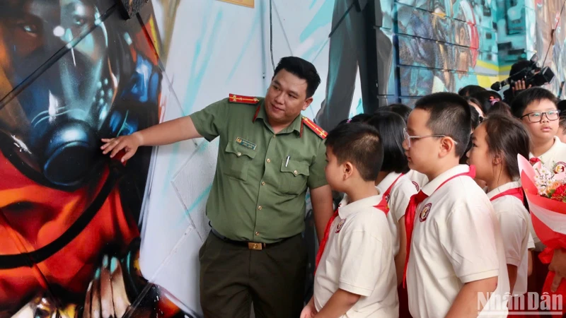 Cán bộ Công an Thành phố Hồ Chí Minh giới thiệu bích hoạ đến các em học sinh.