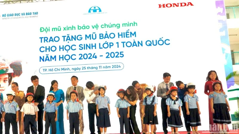 Các đơn vị tổ chức tặng mũ bảo hiểm cho các em học sinh.