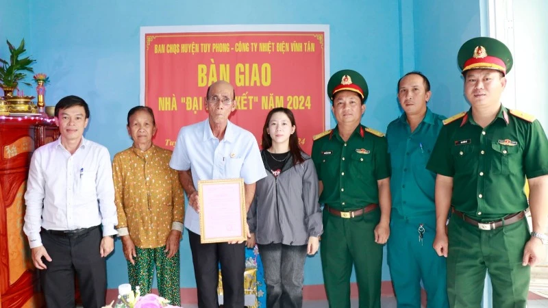 Đại diện Công ty Nhiệt điện Vĩnh Tân và Ban Chỉ huy Quân sự huyện Tuy Phong bàn giao nhà cho gia đình ông Hồ Thái.