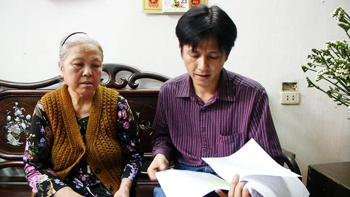 Lê Quang Vinh và mẹ tìm hiểu các thông tin về liệt sĩ.