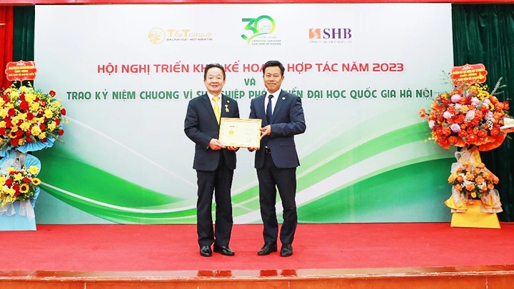 GS, TS Lê Quân (bên phải) trao kỷ niệm chương Vì sự nghiệp phát triển ĐHQGHN cho doanh nhân Đỗ Quang Hiển.