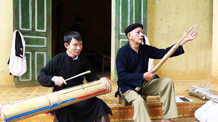 Nghệ nhân Vì Văn Sang (bên phải) giới thiệu về những đạo cụ âm nhạc của đồng bào dân tộc Khơ Mú.