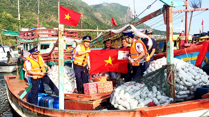 Cảnh sát biển Việt Nam trao cờ Tổ quốc tặng ngư dân trên đảo Phú Quý.