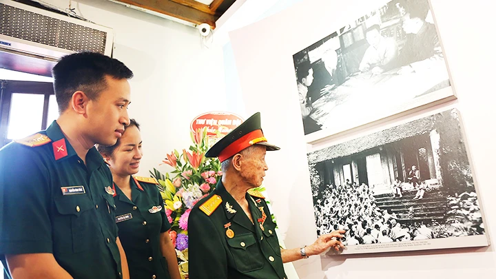 Anh hùng LLVT La Văn Cầu kể với thế hệ trẻ về bức ảnh Bác Hồ với bộ đội tại đền Hùng sau “Tết Độc lập” năm 1954. Ảnh: K.MINH