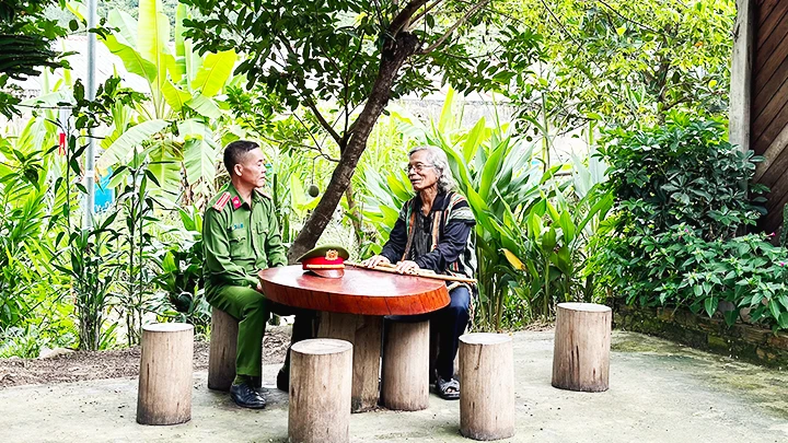Trung tá Ating Chơn, Trưởng công an xã Lăng đến thăm và học hỏi kinh nghiệm của già làng Bríu Pố về công tác giữ gìn an ninh trật tự.