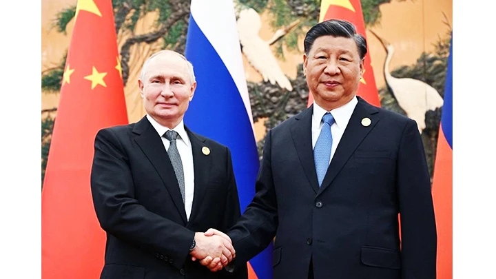 Tổng thống Nga Vladimir Putin (trái) bắt tay Chủ tịch Trung Quốc Tập Cận Bình trước cuộc hội đàm ở Thủ đô Bắc Kinh. Ảnh: SPUTNIK