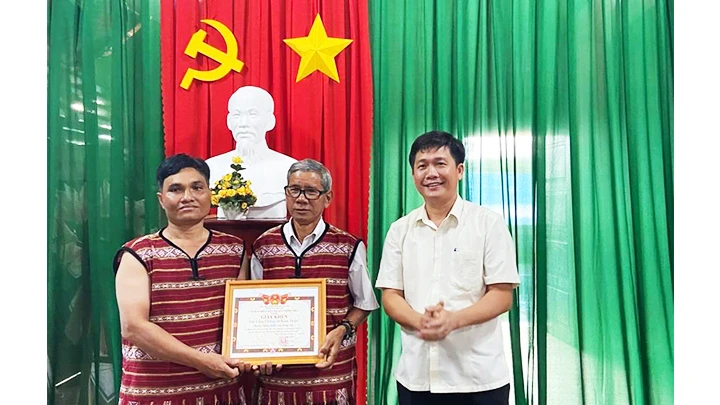 Đồng chí Trần Đức Hòa, Phó Chủ tịch UBND huyện Thống Nhất tặng giấy khen cho già làng Thổ Nơi và anh Điểu Toa. Ảnh: QUANG HOÀNG