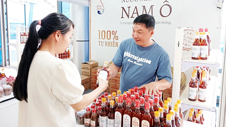 Anh Bùi Thanh Phú giới thiệu sản phẩm nước mắm nhĩ Nam Ô đến khách hàng.
