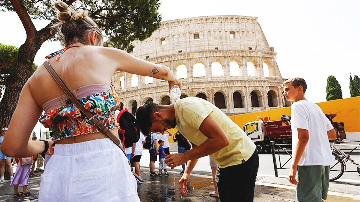 Du khách tưới nước vào người để làm dịu cái nóng ở Italy. Ảnh: REUTERS