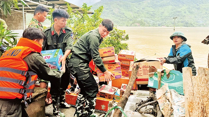 Chiến sĩ Công an tỉnh Bắc Kạn hỗ trợ vận chuyển nhu yếu phẩm vào vùng ngập lũ.