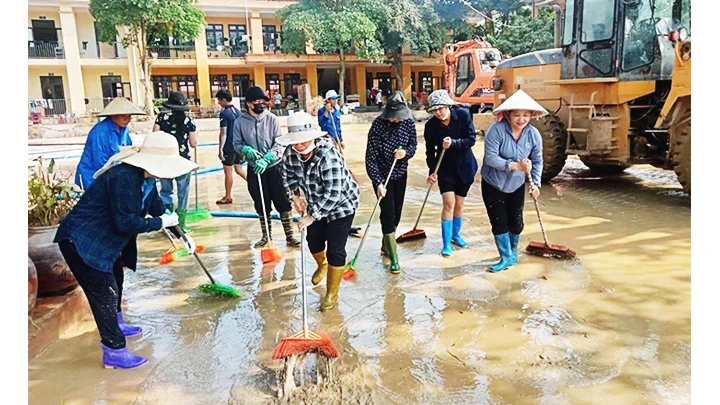 Các cô giáo Trường tiểu học và trung học cơ sở xã Minh Chuẩn, huyện Lục Yên (Yên Bái) tham gia dọn bùn đất sau bão số 3. Ảnh: THANH SƠN