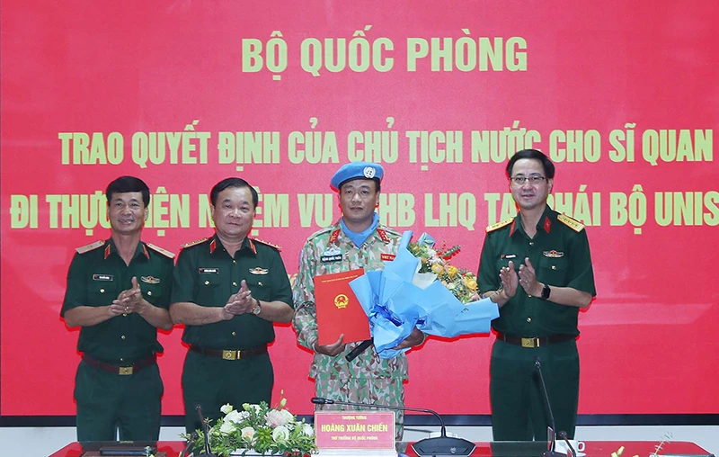 Thượng tướng Hoàng Xuân Chiến trao Quyết định của Chủ tịch nước và tặng hoa chúc mừng Trung tá Đặng Quốc Tuấn. 