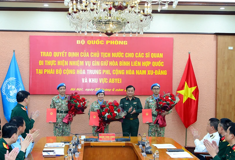 Thượng tướng Hoàng Xuân Chiến trao Quyết định của Chủ tịch nước và tặng hoa chúc mừng ba sĩ quan đi thực hiện nhiệm vụ gìn giữ hòa bình Liên hợp quốc.