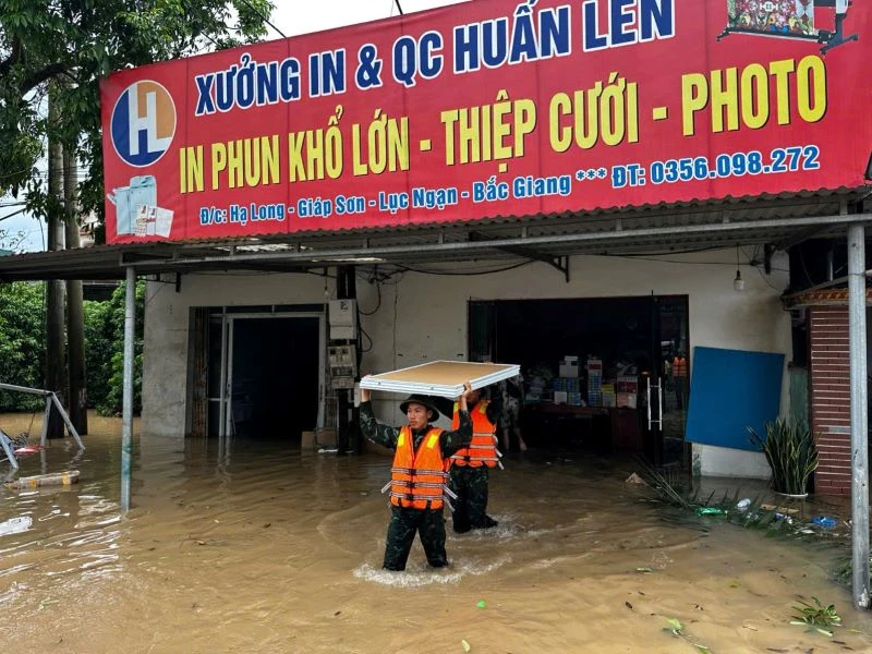 Cán bộ, chiến sĩ Trung đoàn 18, Sư đoàn 325 giúp nhân dân thôn Hạ Long, xã Giáp Sơn, huyện Lục Ngạn, tỉnh Bắc Giang, chuyển đồ đạc đến nơi an toàn. 