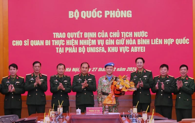 Thượng tướng Phùng Sĩ Tấn cùng đại diện các cơ quan, đơn vị chúc mừng Thiếu tá Hoàng Đình Công chuẩn bị lên đường làm nhiệm vụ giữ gìn hòa bình Liên hợp quốc. 