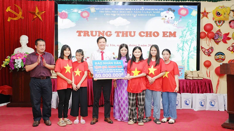 Đại diện Báo Nhân Dân và Công ty cổ phần Văn hóa Đọc và Học Việt Nam tặng quà cho nhà trường.