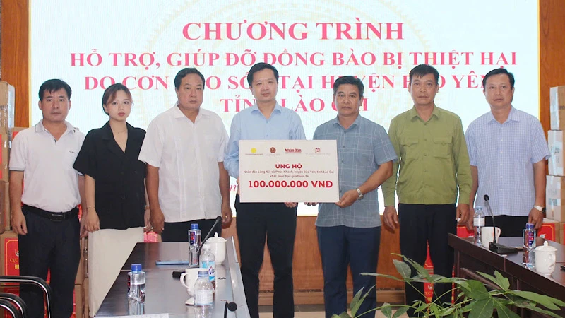 Đại diện Báo Nhân Dân, các nhà tài trợ và lãnh đạo Ủy ban nhân dân huyện Bảo Yên, tỉnh Lào Cai, trao và nhận biểu trưng hỗ trợ nhân dân Làng Nủ, xã Phúc Khánh, huyện Bảo Yên, tỉnh Lào Cai.