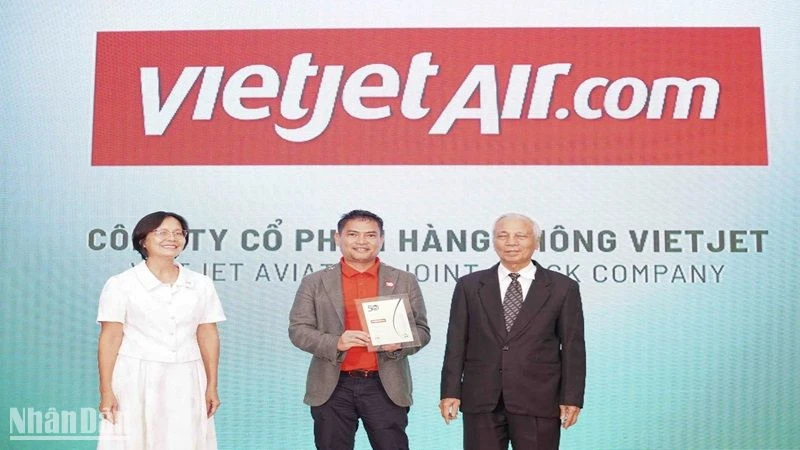 Ông Nguyễn An Di, Giám đốc Nhân sự Vietjet (đứng giữa) nhận giải thưởng tôn vinh 50 doanh nghiệp phát triển bền vững từ ban tổ chức.