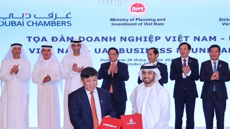 Đại diện lãnh đạo Vietjet (trái) và Emirates (phải) trao thỏa thuận hợp tác mở rộng kết nối quốc tế trước sự chứng kiến của Thủ tướng Phạm Minh Chính (giữa) tại Dubai, UAE.