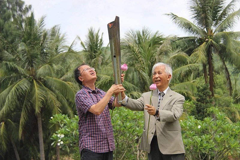 Giáo sư Đàm Thanh Sơn (bên trái) nhận đuốc khoa học từ Giáo sư Trần Thanh Vân trong lễ khai mạc chương trình gặp gỡ Việt Nam 2022. Ảnh: ICISE