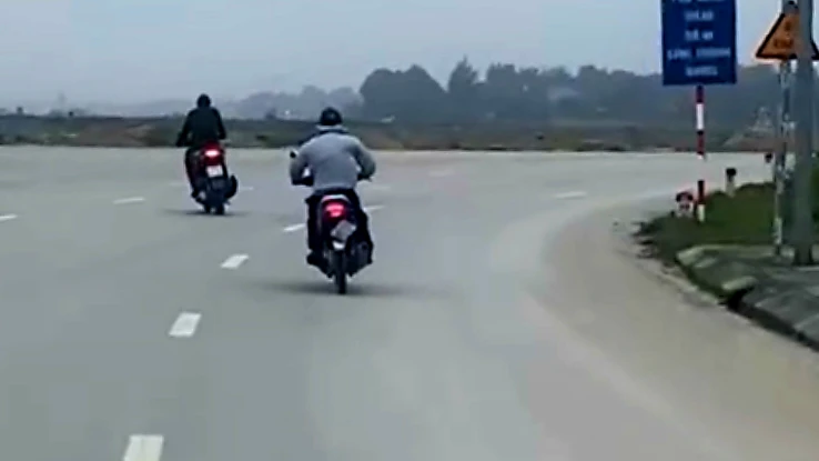 Đối tượng cướp (áo màu ghi) tẩu thoát bằng xe máy. (Ảnh cắt từ video clip)