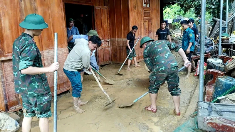 Lực lượng vũ trang và các tổ chức đoàn thể hỗ trợ các gia đình dọn dẹp bùn đất.