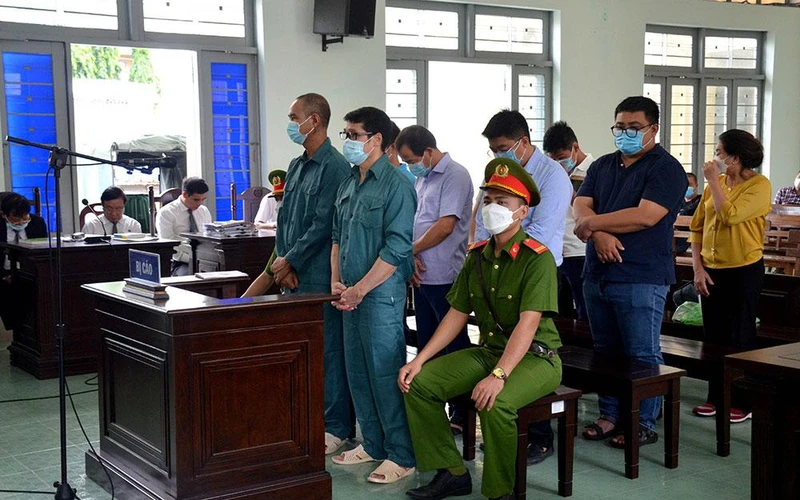 Bị cáo Luyện Xuân Tràng (đứng hàng trước, đeo kính) cùng 8 bị cáo tại phiên tòa.