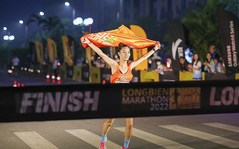 Một nữ vận động viên về đích tại giải chạy Longbien Marathon 2022 sáng sớm 30/10.