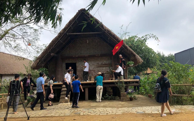Du khách tham quan nhà Ê Đê tại Làng Văn hóa-Du lịch các dân tộc Việt Nam.