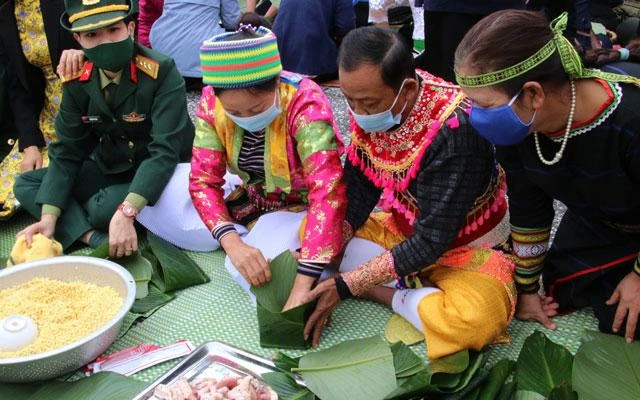 Đồng bào dân tộc cùng các chiến sĩ tham gia chương trình gói "Bánh chưng xanh" tại Làng. (Ảnh: Làng Văn hóa-Du lịch các dân tộc Việt Nam)