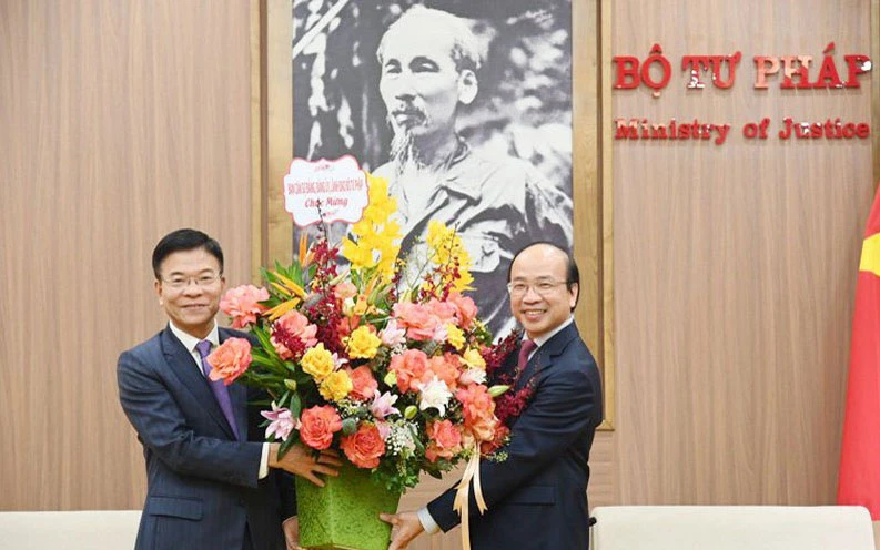 Bộ trưởng Tư pháp Lê Thành Long tặng hoa, chúc mừng tân Chủ tịch Viện Hàn lâm Khoa học Xã hội Việt Nam Phan Chí Hiếu. (Ảnh: Báo Pháp luật)