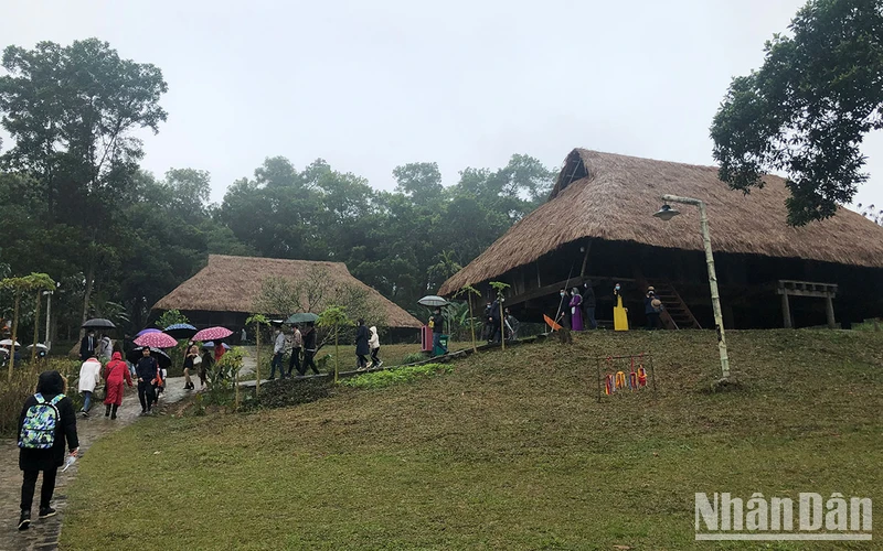 Du khách tham quan làng Mường tại Làng Văn hóa Du lịch các dân tộc Việt Nam.