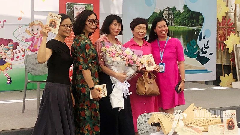 Tác giả Vũ Thị Minh Họa (ôm hoa, đứng giữa) tại buổi ra mắt sách.
