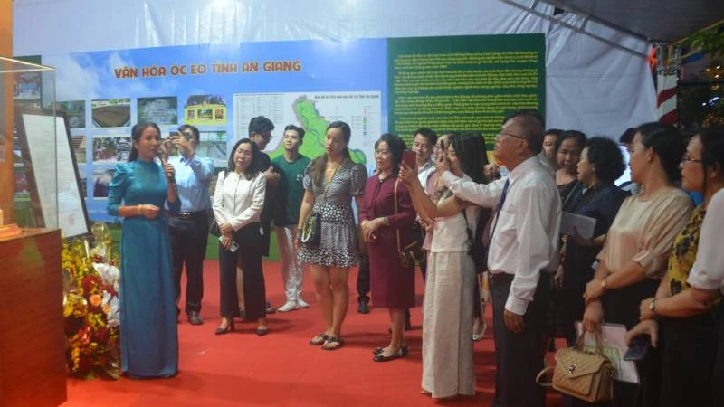 Du khách nghe nhân viên Bảo tàng tỉnh An Giang thuyết minh các bảo vật quốc gia tại An Giang.