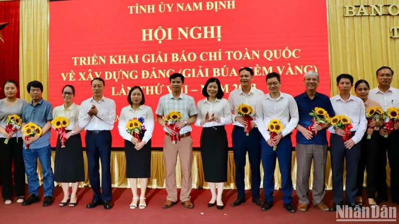 Các đồng chí trong Ban Thường vụ Tỉnh ủy Nam Định tặng hoa chúc mừng các tập thể có thành tích tiêu biểu trong triển khai hưởng ứng Giải Búa liềm vàng lần thứ VII năm 2022.