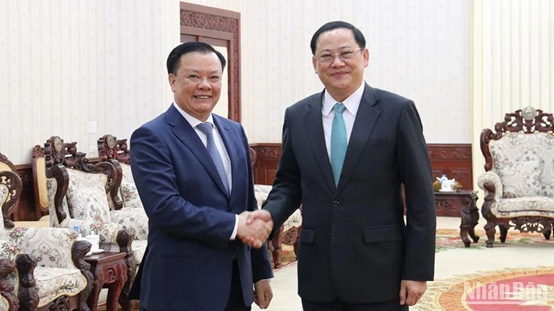 Bí thư Thành ủy Hà Nội Đinh Tiến Dũng (bên trái) và Thủ tướng Lào Sonexay Siphandone. (Ảnh: TRỊNH DŨNG)