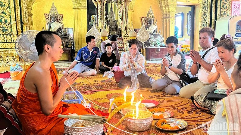 Người dân Lào tham gia nghi lễ buộc chỉ cổ tay đón năm mới 2567 theo Phật lịch của Lào. Ảnh: Trịnh Dũng