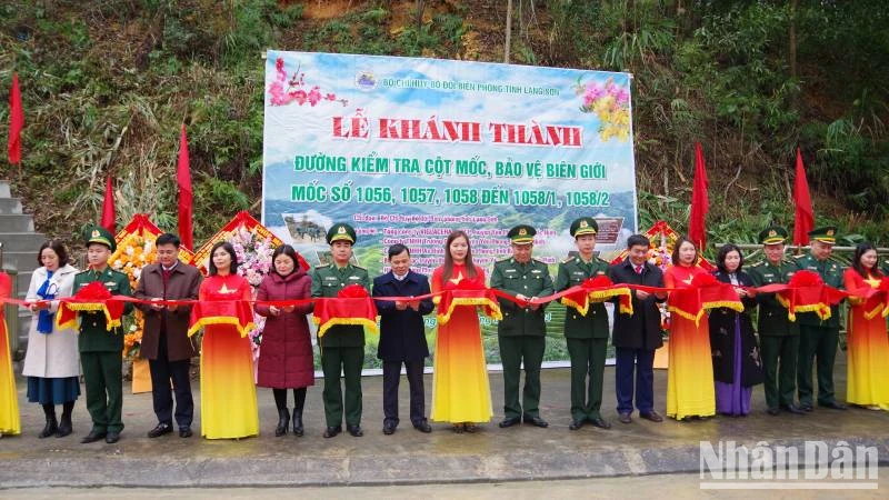 Cán bộ, chiến sĩ Đồn Biên phòng Na Hình, Văn Lãng, (Lạng Sơn), cùng các nhà tài trợ tham gia cắt băng khánh thành đường kiểm tra mốc bảo vệ biên giới. 
