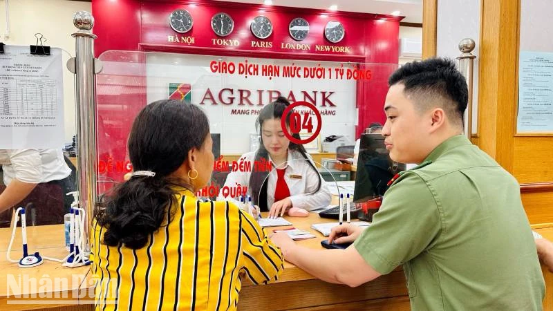 Giao dịch viên Agribank chi nhánh huyện Bắc Sơn và cán bộ đội an ninh, Công an huyện Bắc Sơn, hỗ trợ, tư vấn cho khách hàng suýt bị lừa đảo qua mạng.