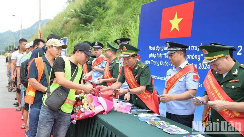 Cán bộ, chiến sĩ Đồn Biên phòng Tân Thanh, huyện Văn Lãng, Lạng Sơn (Việt Nam) và lực lượng chức năng Trạm Kiểm tra Biên phòng Pò Chài, Quảng Tây (Trung Quốc), phối hợp phát tờ rơi tuyên truyền pháp luật cho người dân qua lại biên giới. 