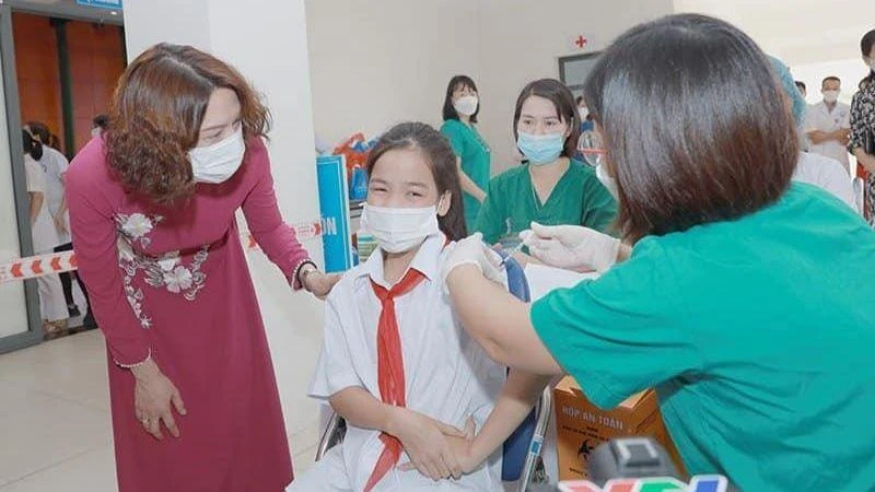 Thứ trưởng Nguyễn Thị Liên Hương động viên các em học sinh tham gia tiêm chủng.