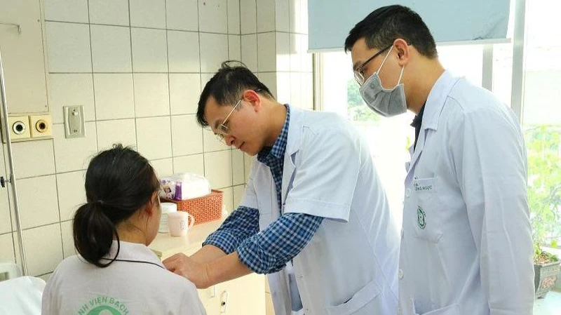 Bác sĩ Ngô Gia Khánh và bác sĩ Nguyễn Văn Minh kiểm tra cho bệnh nhân.