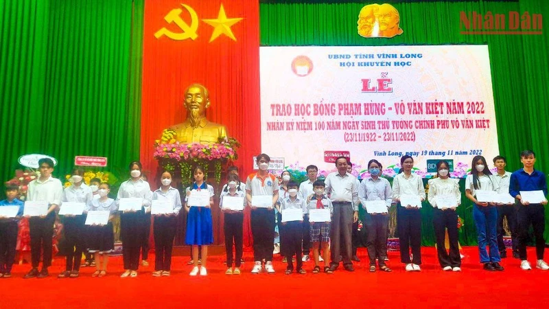 Phó Bí thư thường trực Tỉnh ủy Vĩnh Long Nguyễn Thành Thế trao học bổng cho các em học sinh vượt khó học giỏi. (Ảnh: BÁ DŨNG) 