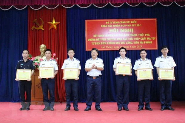 Trung tá Phạm Văn Đồng Đoàn trưởng Đoàn Đặc nhiệm phòng chống tội phạm ma tuý số 1 trao tặng Giấy khen cho các cá nhân. (Ảnh: TTXVN phát)