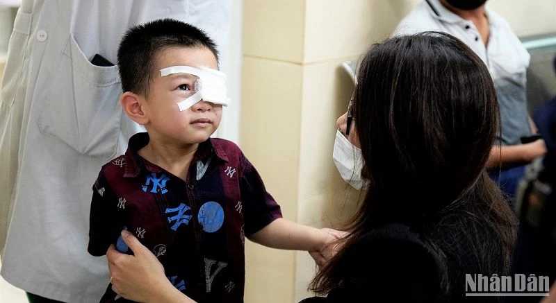 Trẻ bị đau mắt đỏ vừa được bác sĩ bóc giả mạc. (Ảnh: THẾ KHẢI)