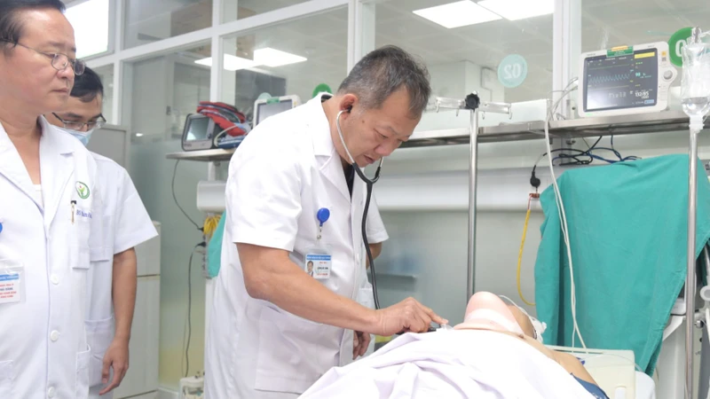 Tiến sĩ Dương Đức Hùng, Giám đốc Bệnh viện Hữu nghị Việt Đức khám cho bệnh nhân trước khi đưa vào phòng mổ. (Ảnh: BVCC)