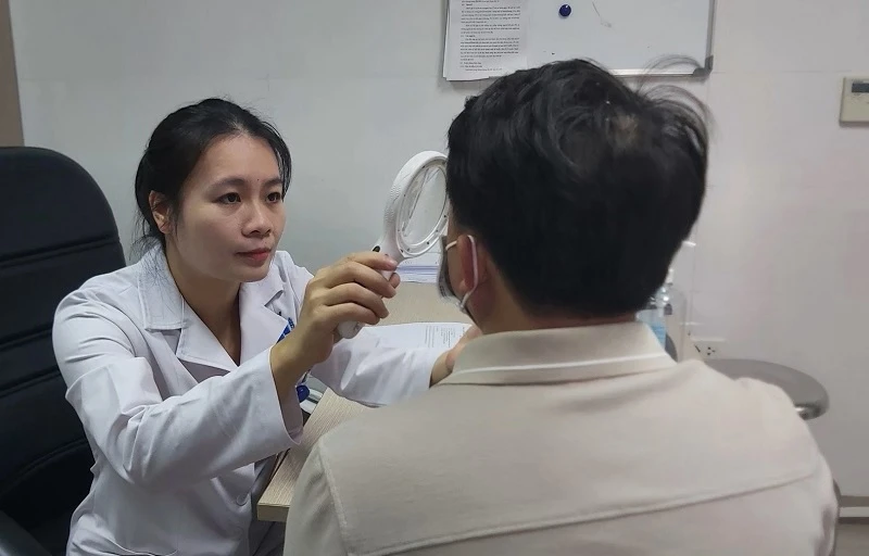 Bác sĩ Quách Thị Hà Giang đang khám cho 1 bệnh nhân bị viêm da tiếp xúc với kiến ba khoang.