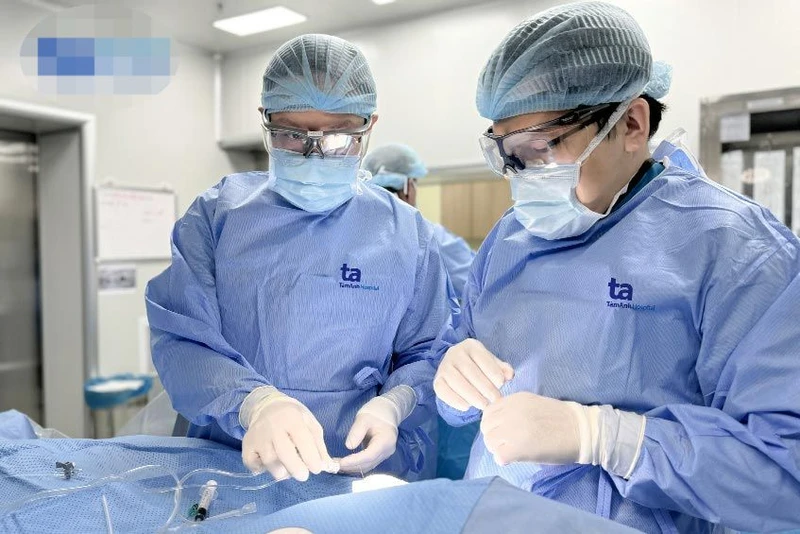 Bác sĩ chuyên khoa I Vũ Năng Phúc (bên phải) cùng ê-kíp can thiệp cấp cứu cứu bé sơ sinh 2 giờ tuổi bị dị tật tim bẩm sinh.